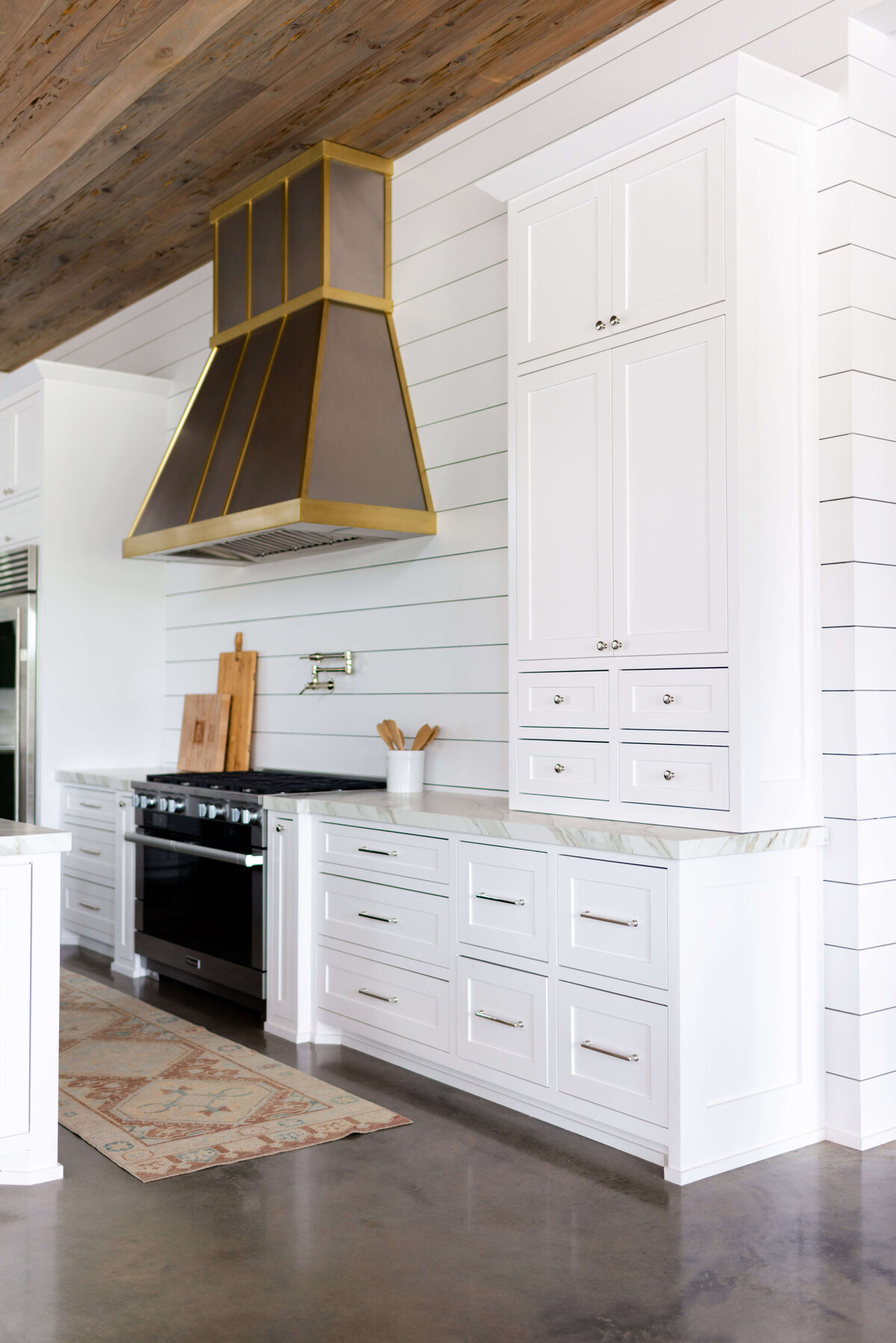 oyster creek studios building belt new build white kitchen with brown floors and large cabinets