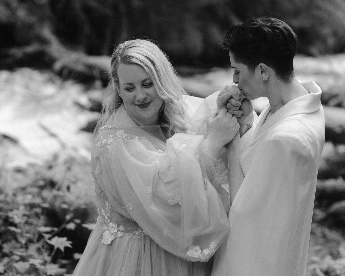 Two brides holding hands at their first look
