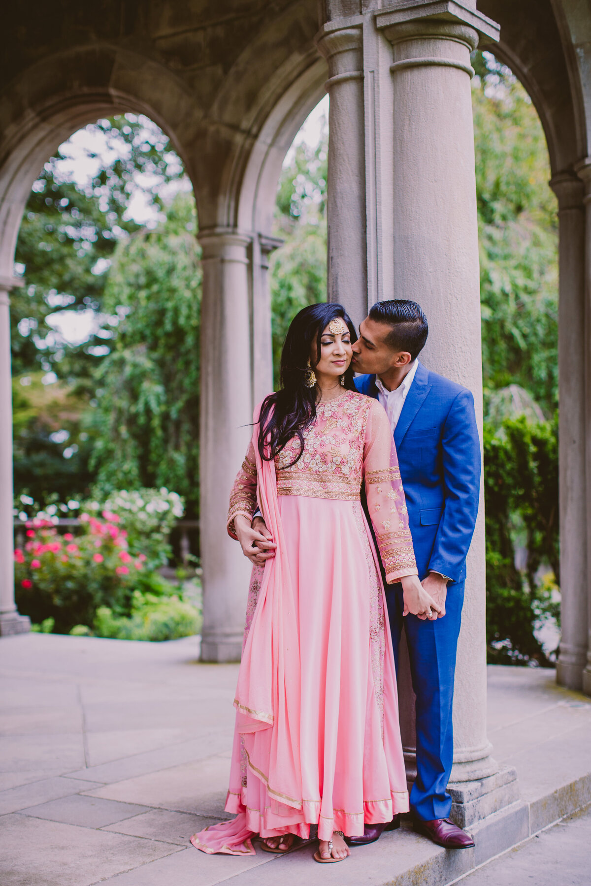 an engaged couple having a moment near the arches of a mansion at planting fields arboretum in oyster bay ny