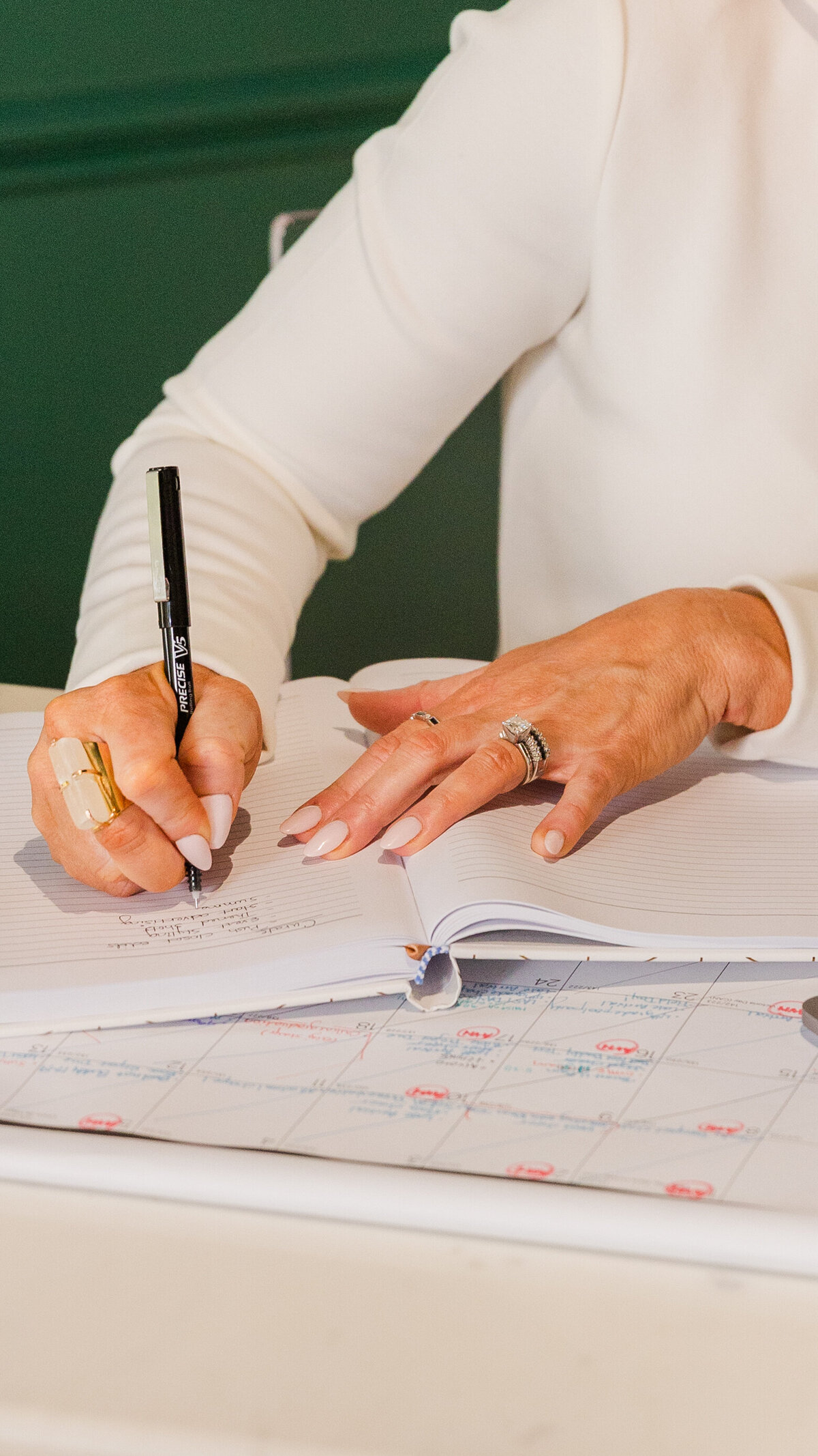 detail of woman's hands writing on a notebook during photoshootAtlanta