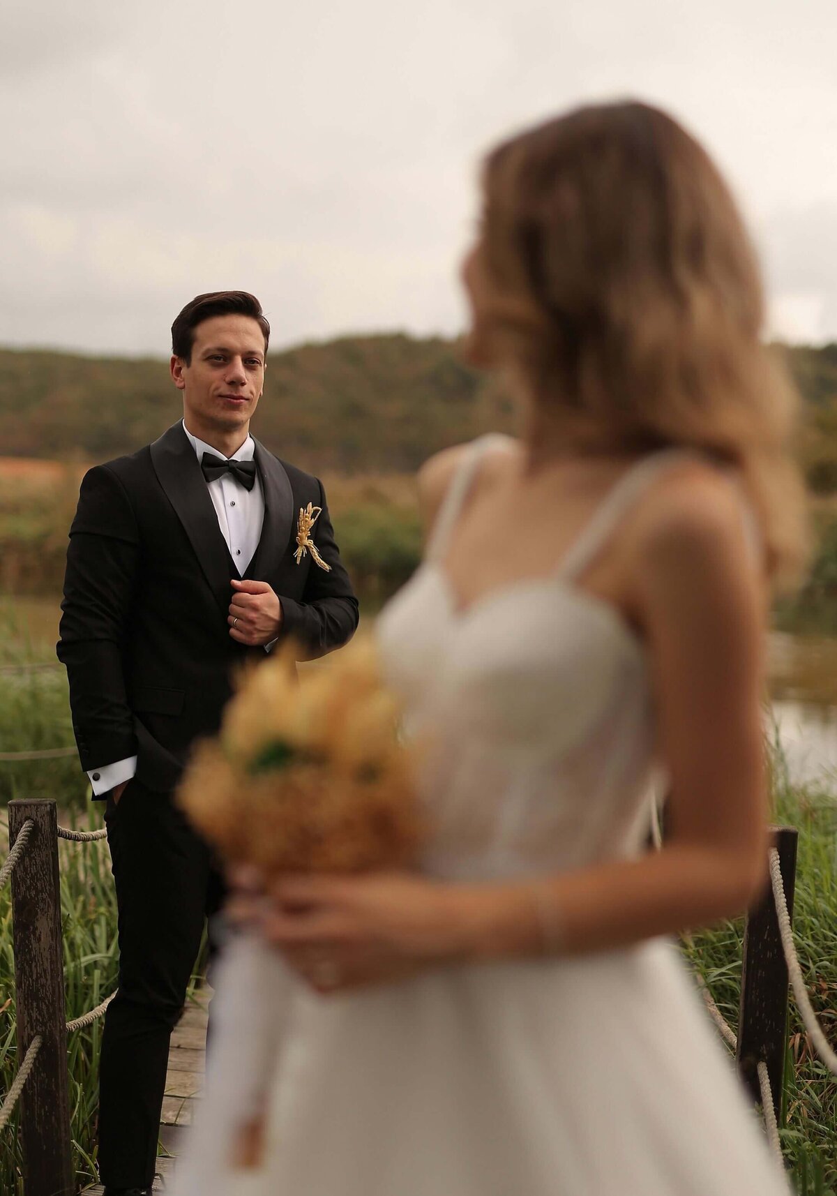 A bride and groom standing on a bridge