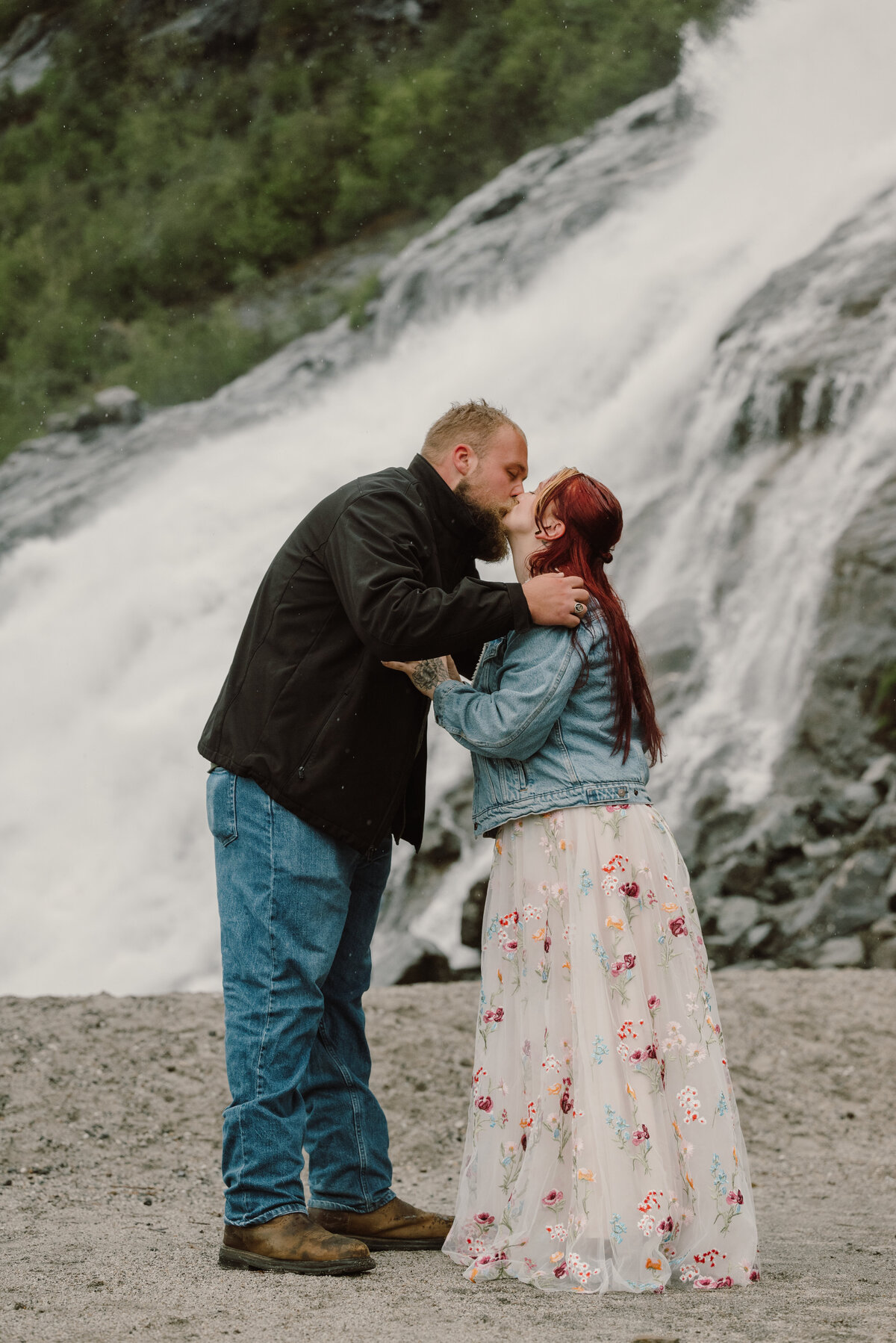 couple kissing by the waterfall