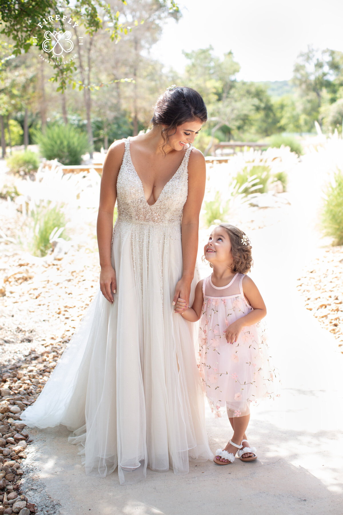 bride and flower girl light and airy scene at Geronimo Oaks wedding venue in Seguin by San Antonio wedding photographer Firefly Photography