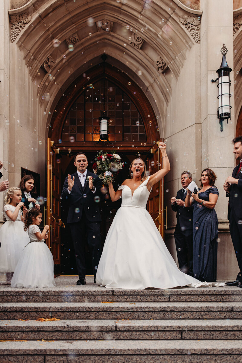 Bride and groom celebrate as they leave St.John Cathedral Church