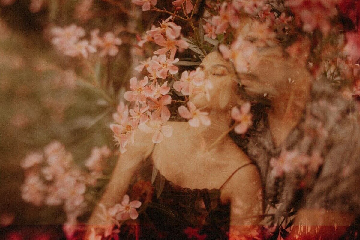 A romantic double exposure photo of a couple surrounded by pink flowers.