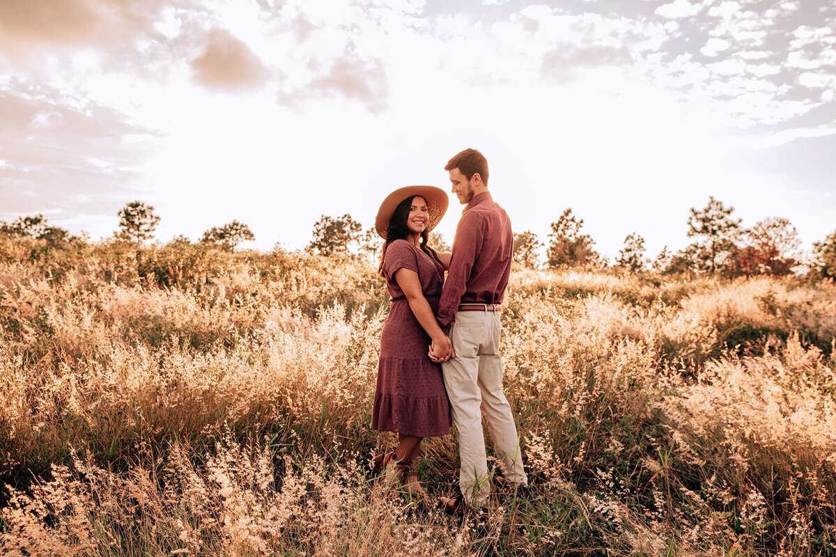 engaged couple standing in field in clermont for engagement photo