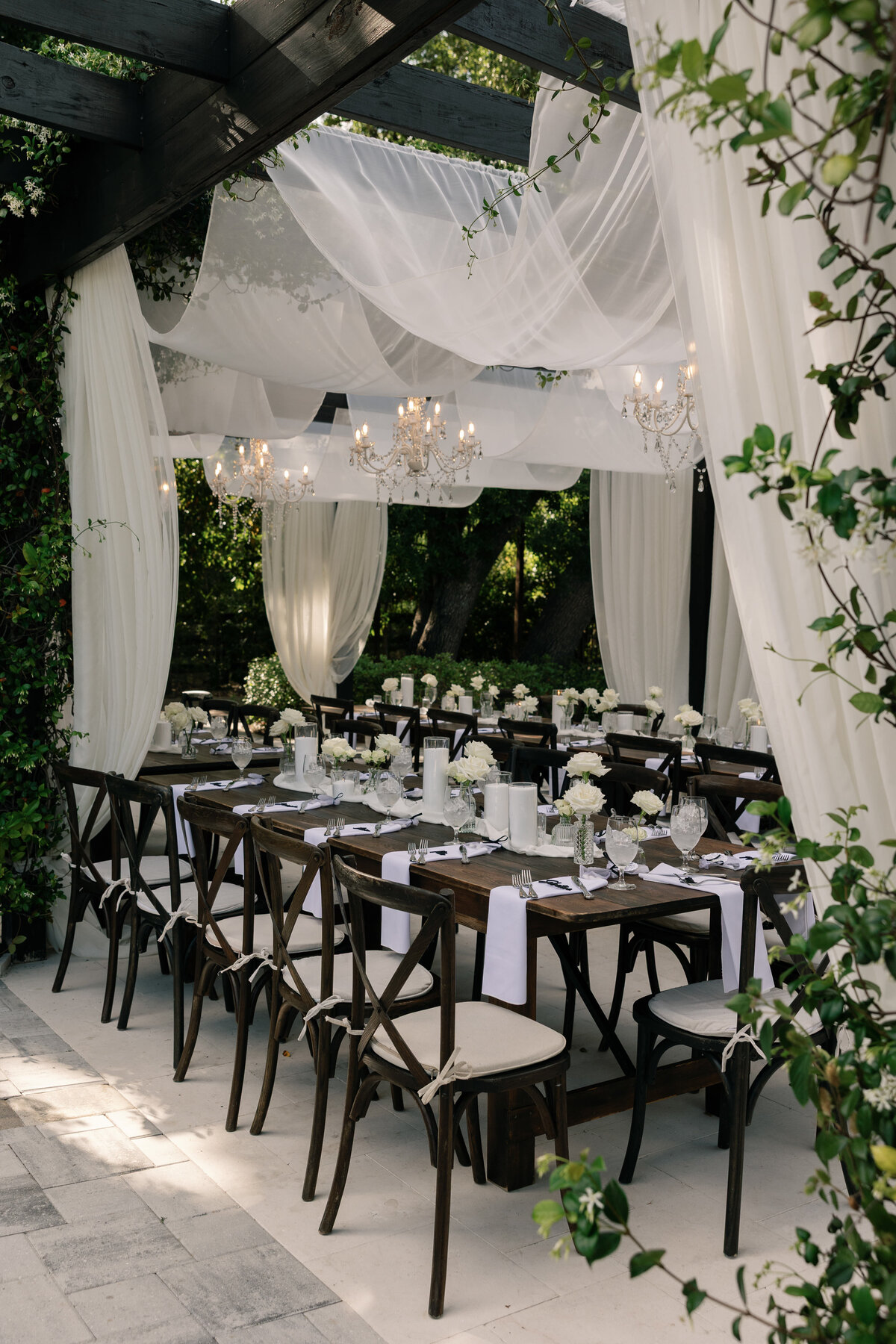 Elegant outdoor reception under chandeliers at La Casa Toscana wedding 