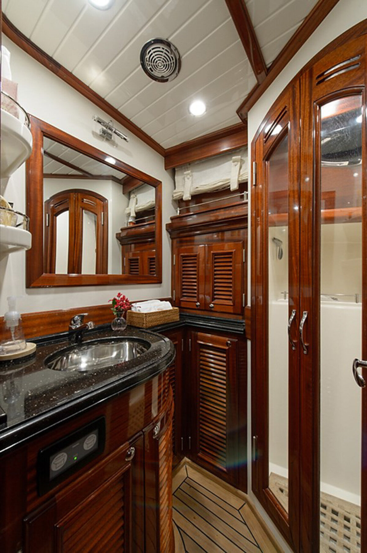 small, elegant bathroom featuring rich wood paneling and cabinetry