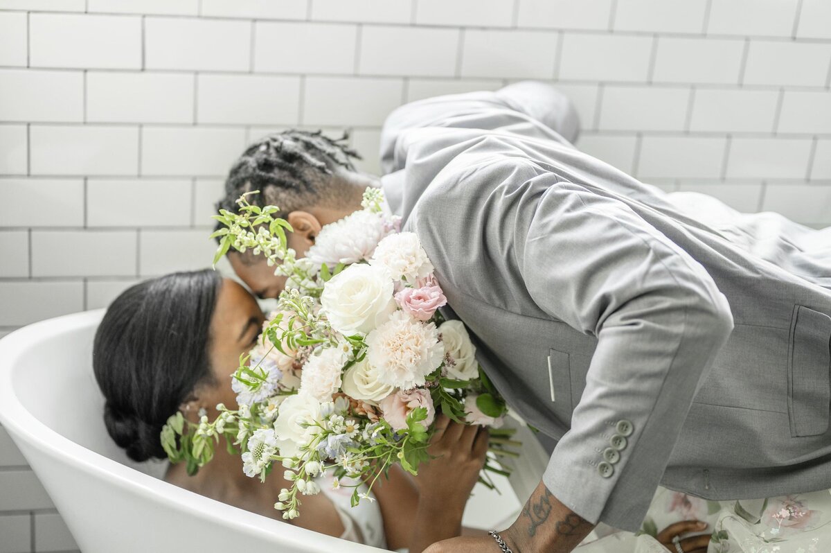 Groom and bride kiss in decorative tub