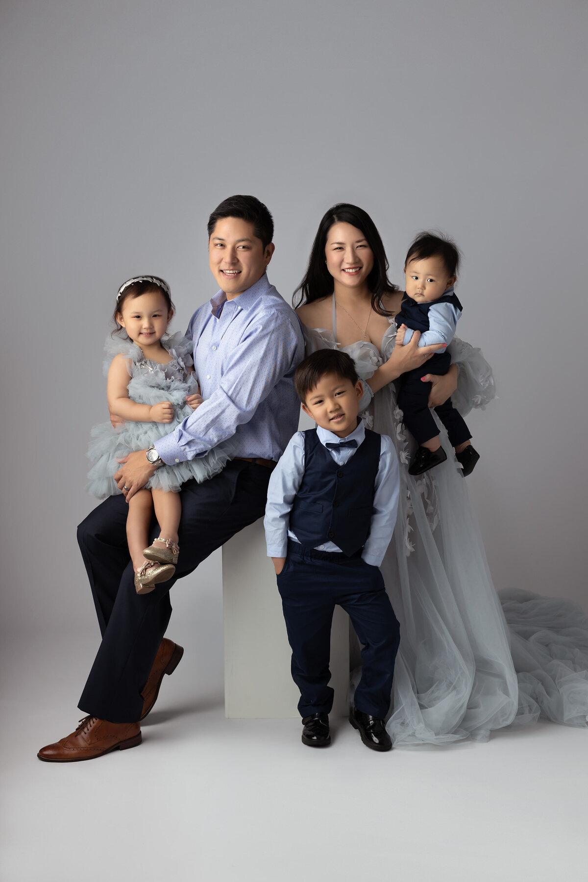 A beautiful family dressed in coordinated attire captured in a fine art family photography session by a Dallas family photographer.
