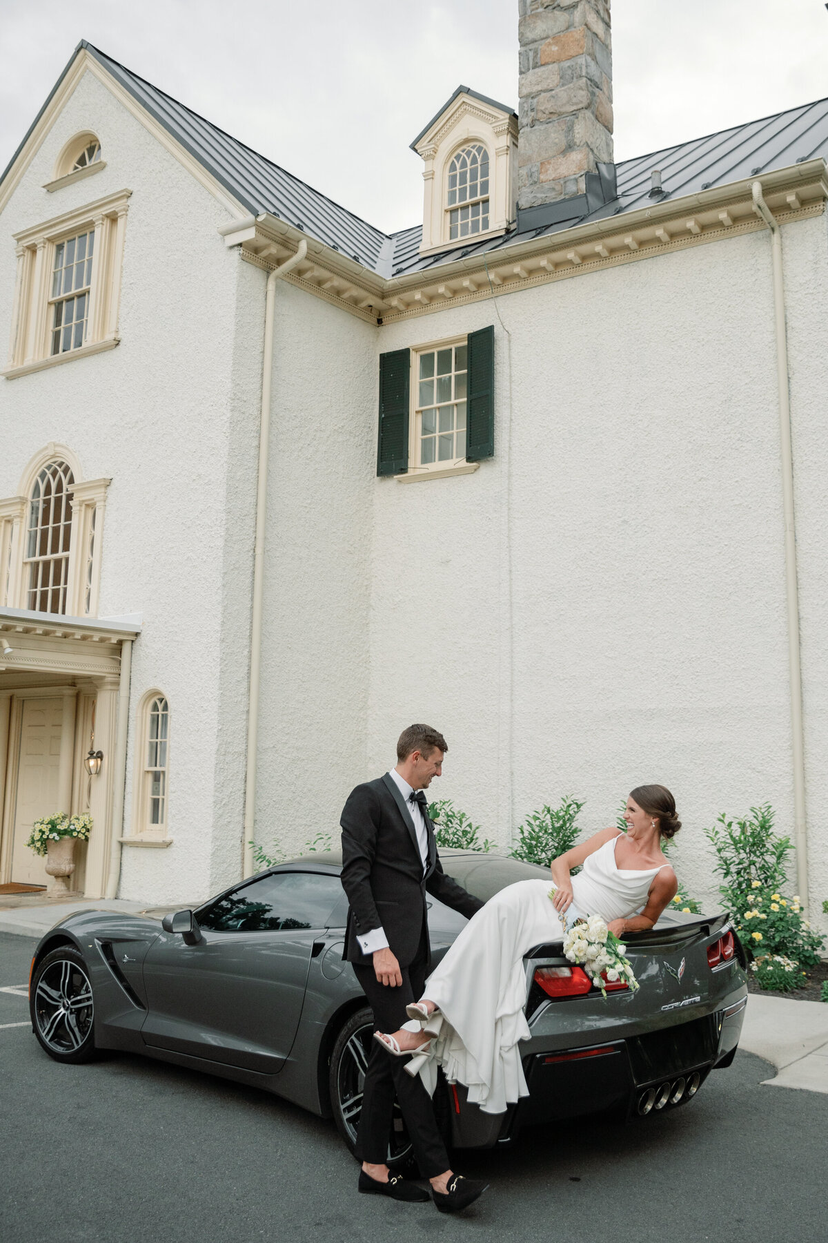 Bride and groom with getaway car parked in front of Rust Manor House