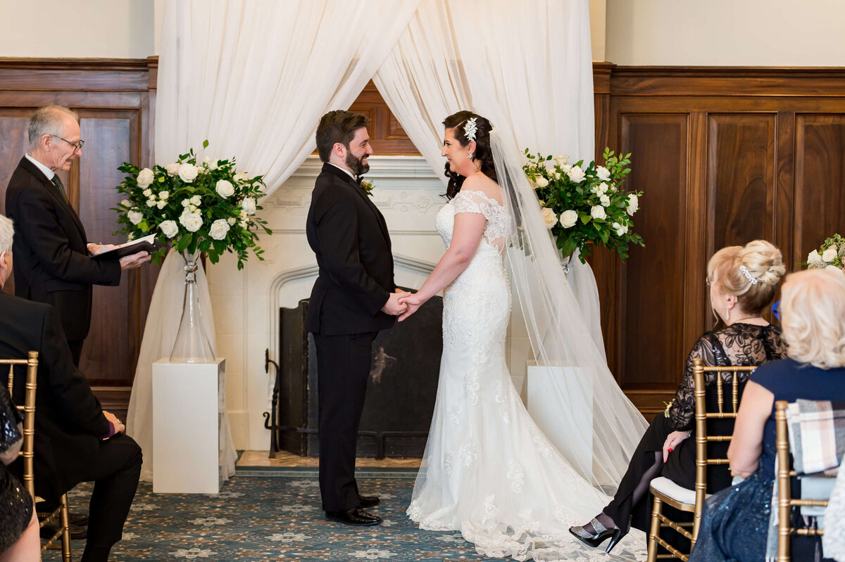 a bride and groom exchange vows in front of the Chateau Laurier fireplace during their Ottawa wedding photography