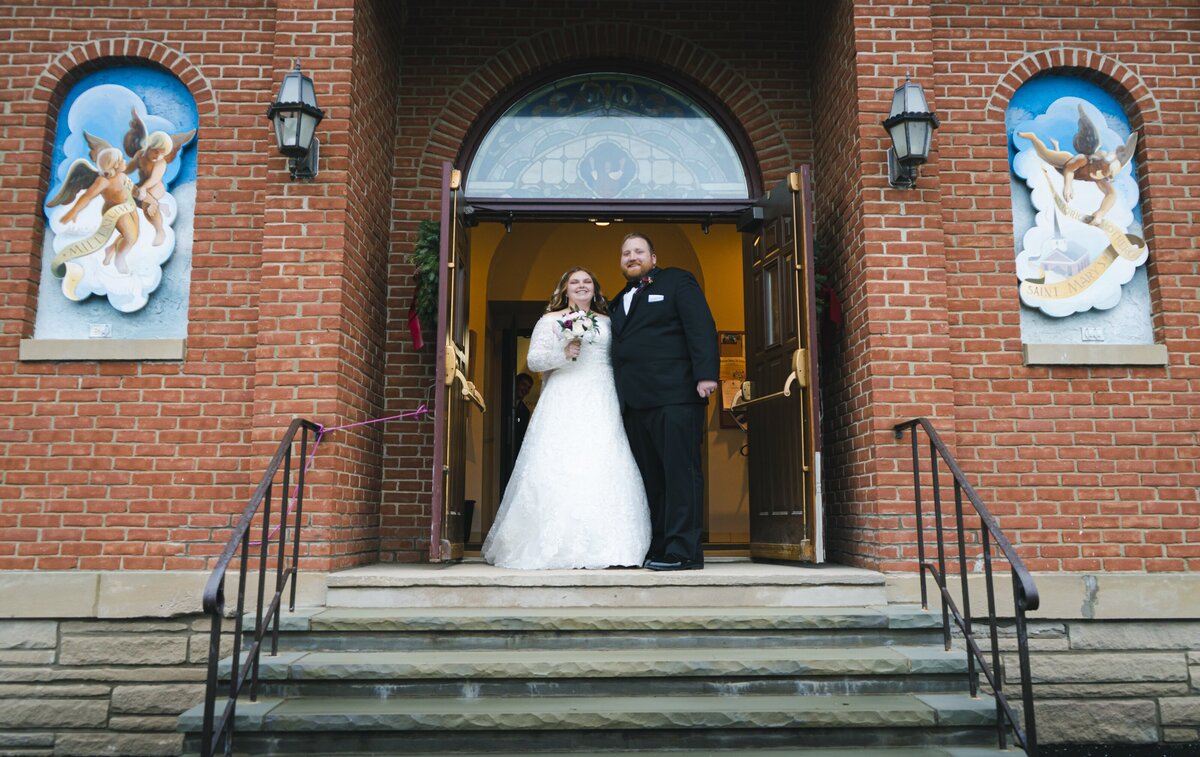 Photo of newlyweds standing outside their venue