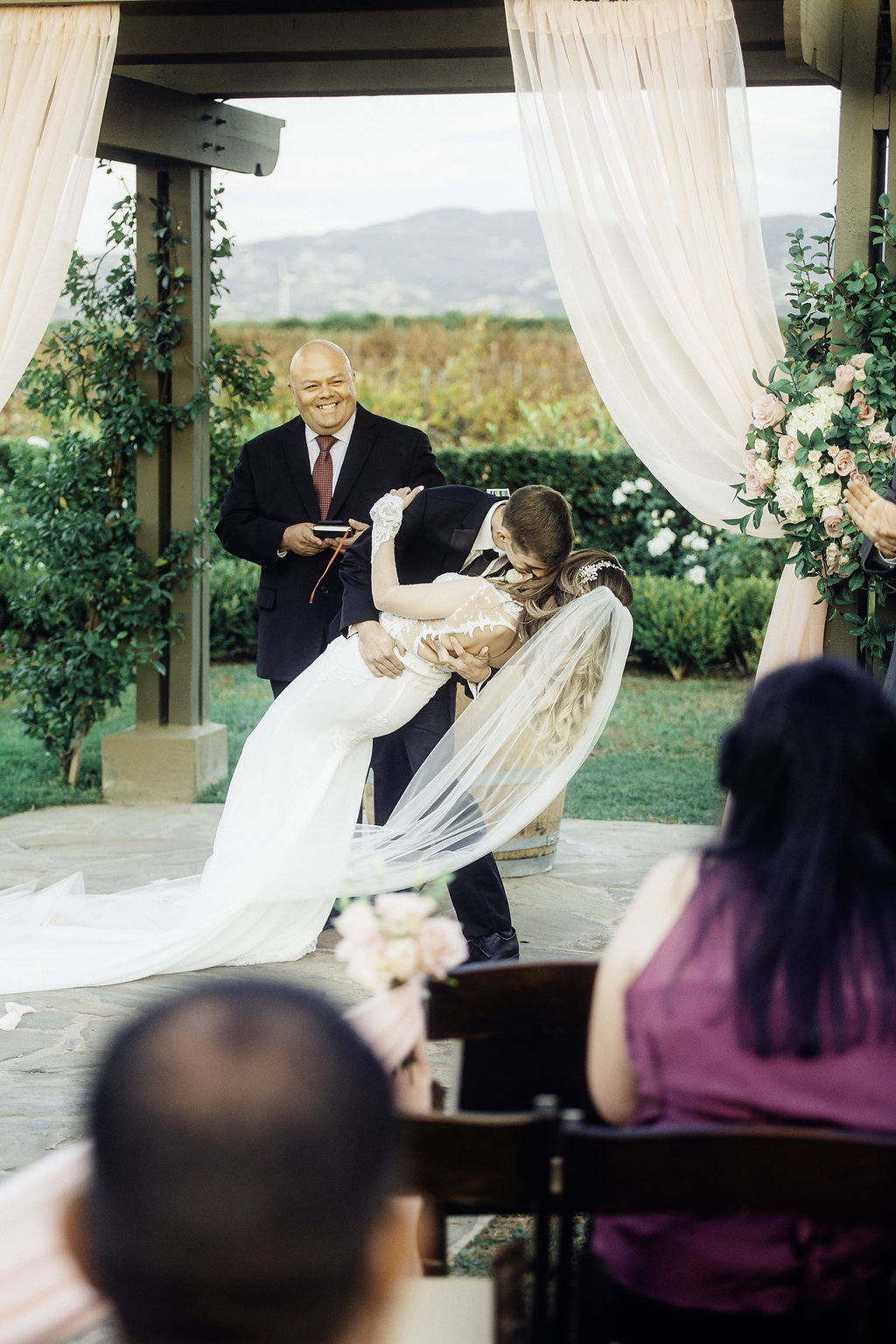 Wedding Photograph Of Pastor Smiling To Bride And Groom Kissing  Los Angeles