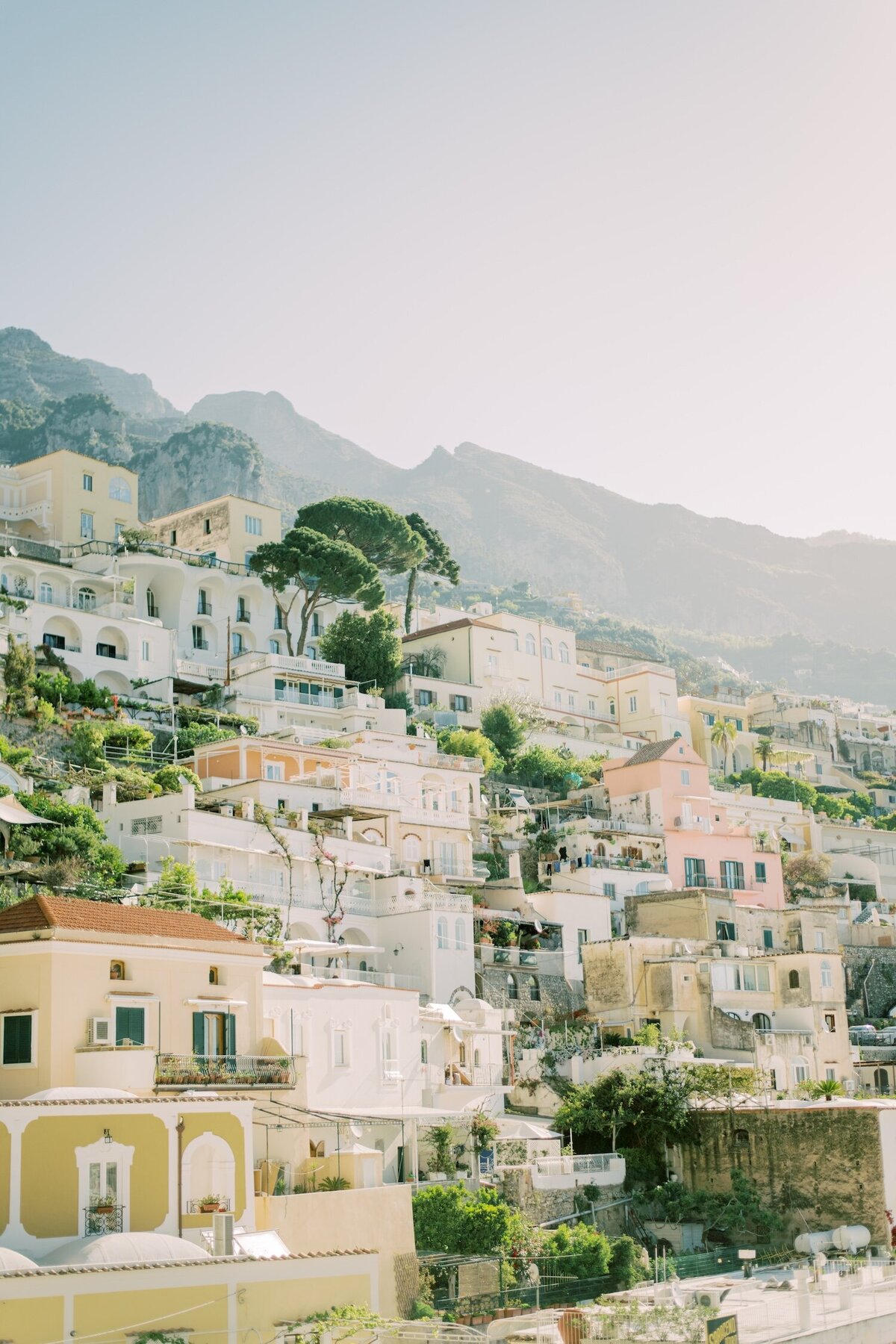 Sunlit hillside buildings on the Amalfi Coast, capturing Christine Grace’s inspiration from European travel and romantic landscapes.