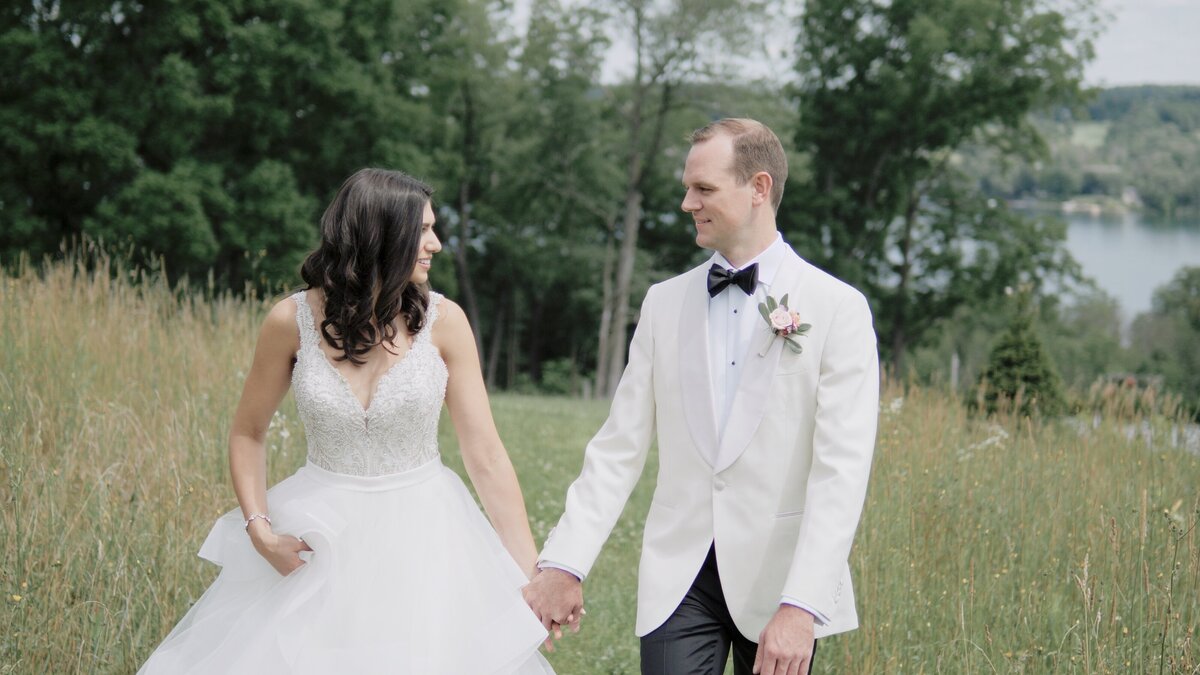 Bride and groom walking in field at Crispin Hill
