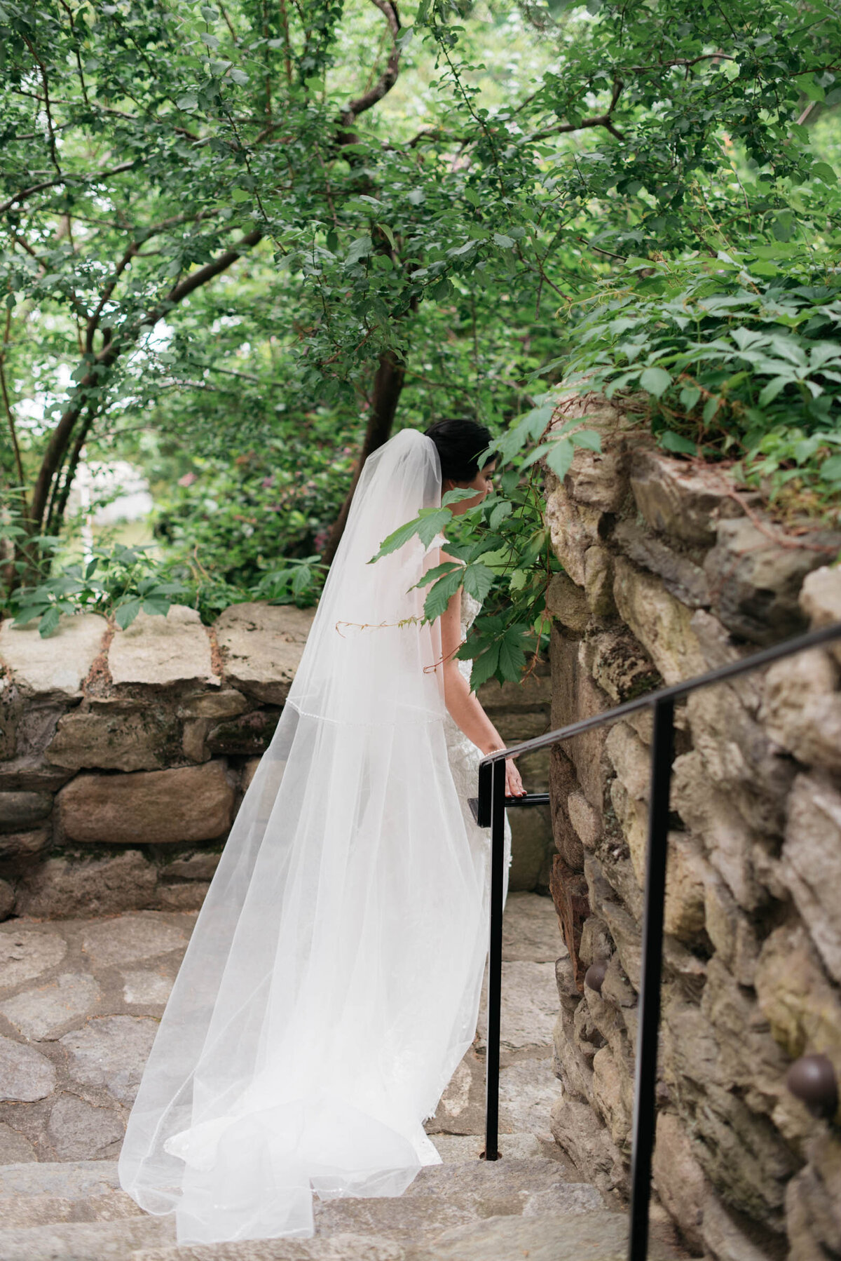 bride walking down stone stairs at connors center wedding venue