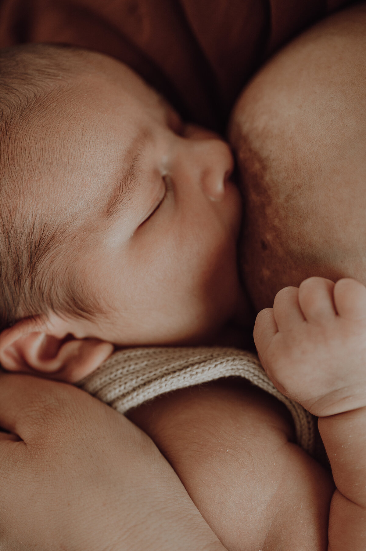 Mama geeft borstvoeding aan baby tijdens newborn fotoshoot