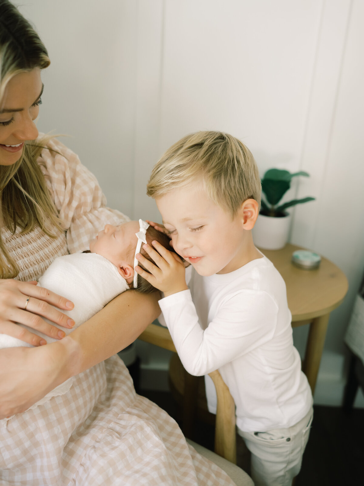 Older sibling hugging newborn sister in orange county newborn session