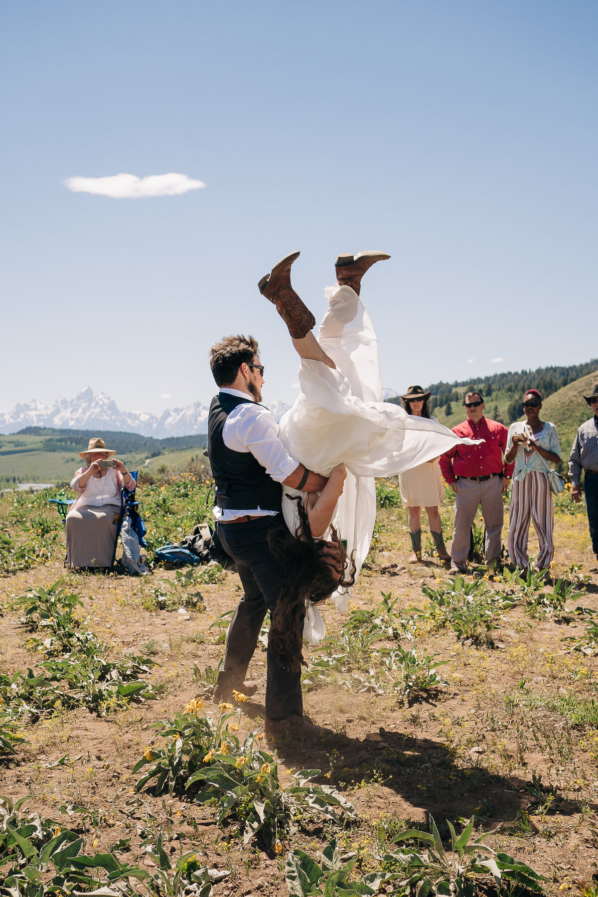 Couple doing a flip during their first dance in front of the Tetons