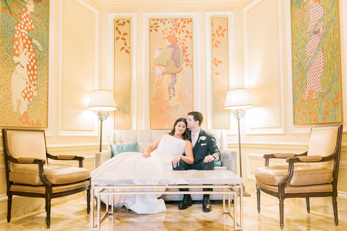 Bride and groom sitting together on sofa.