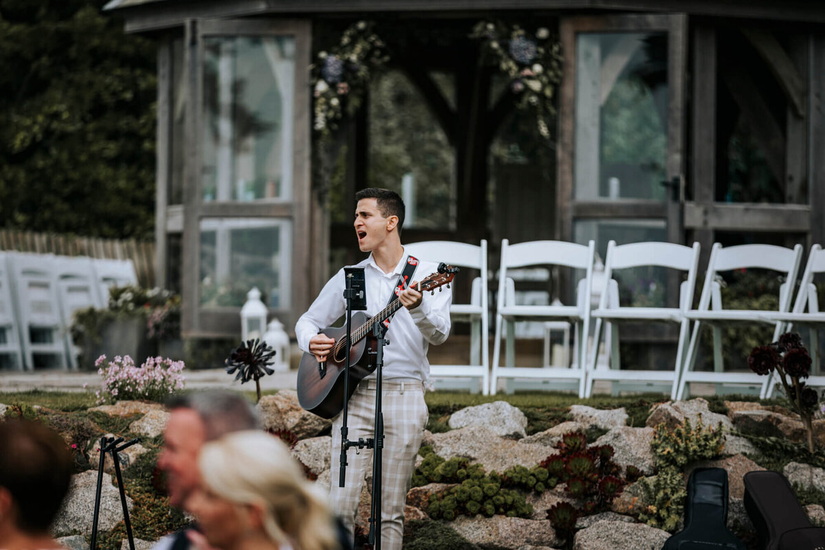 A man playing a guitar in front of a group of people