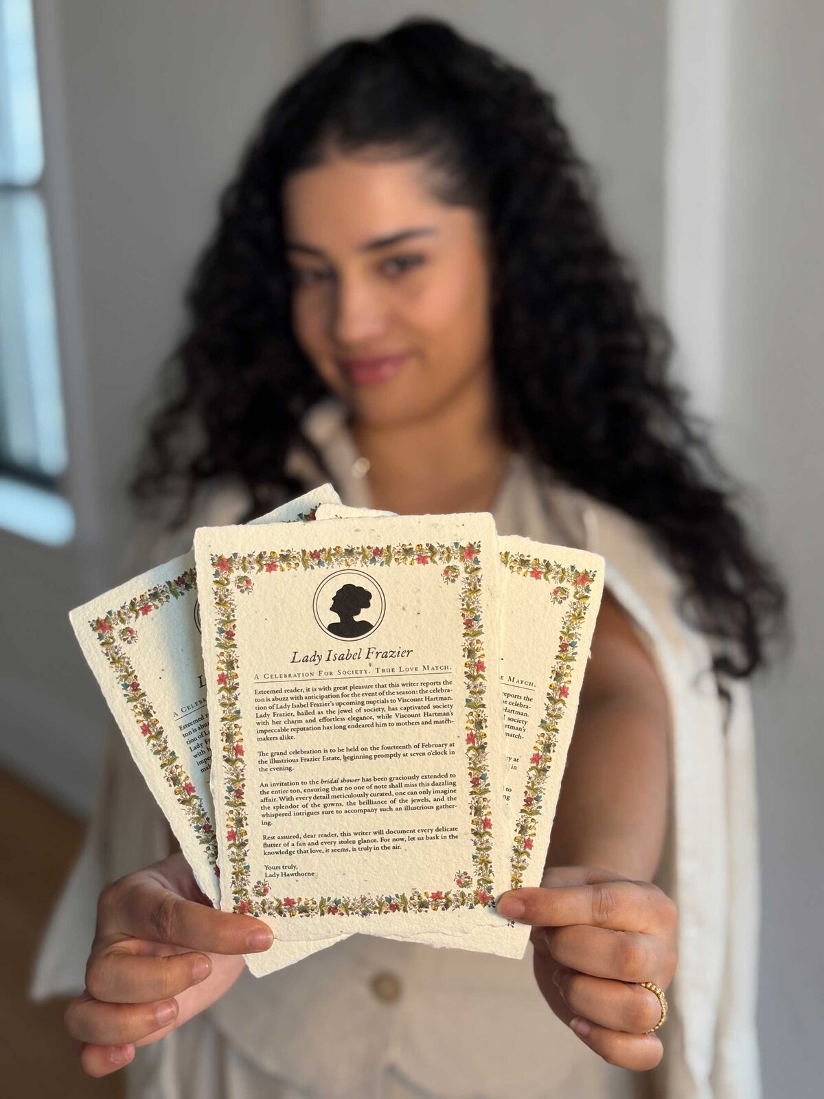 Dark haired woman holding vintage style invitations