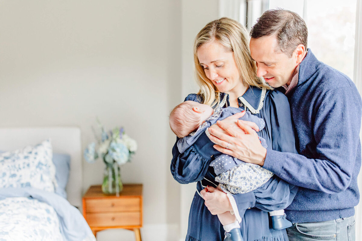 South Boston parents stand together and smile at their newborn