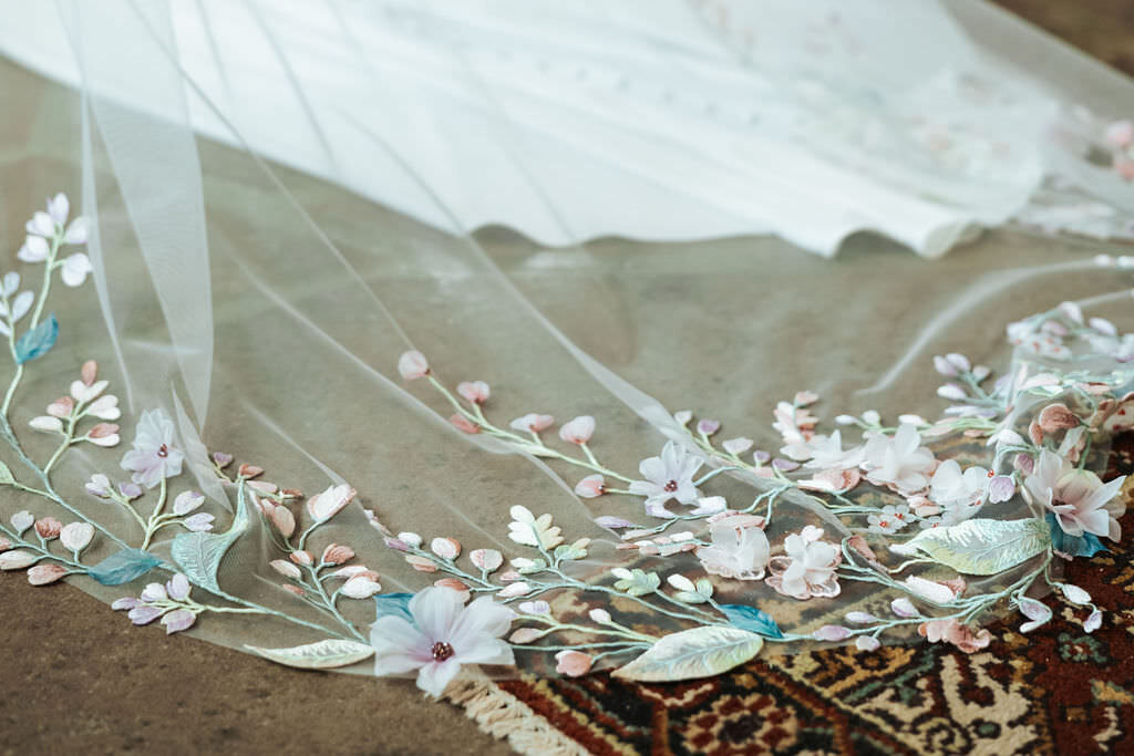 The bottom of a wedding dress train with lace details