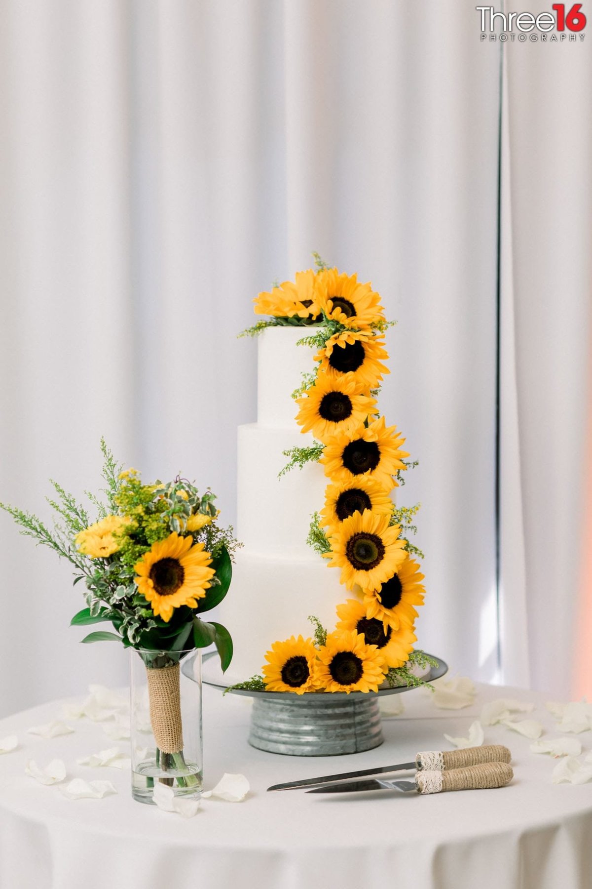Unique three-tiered wedding cake with sunflowers draping down