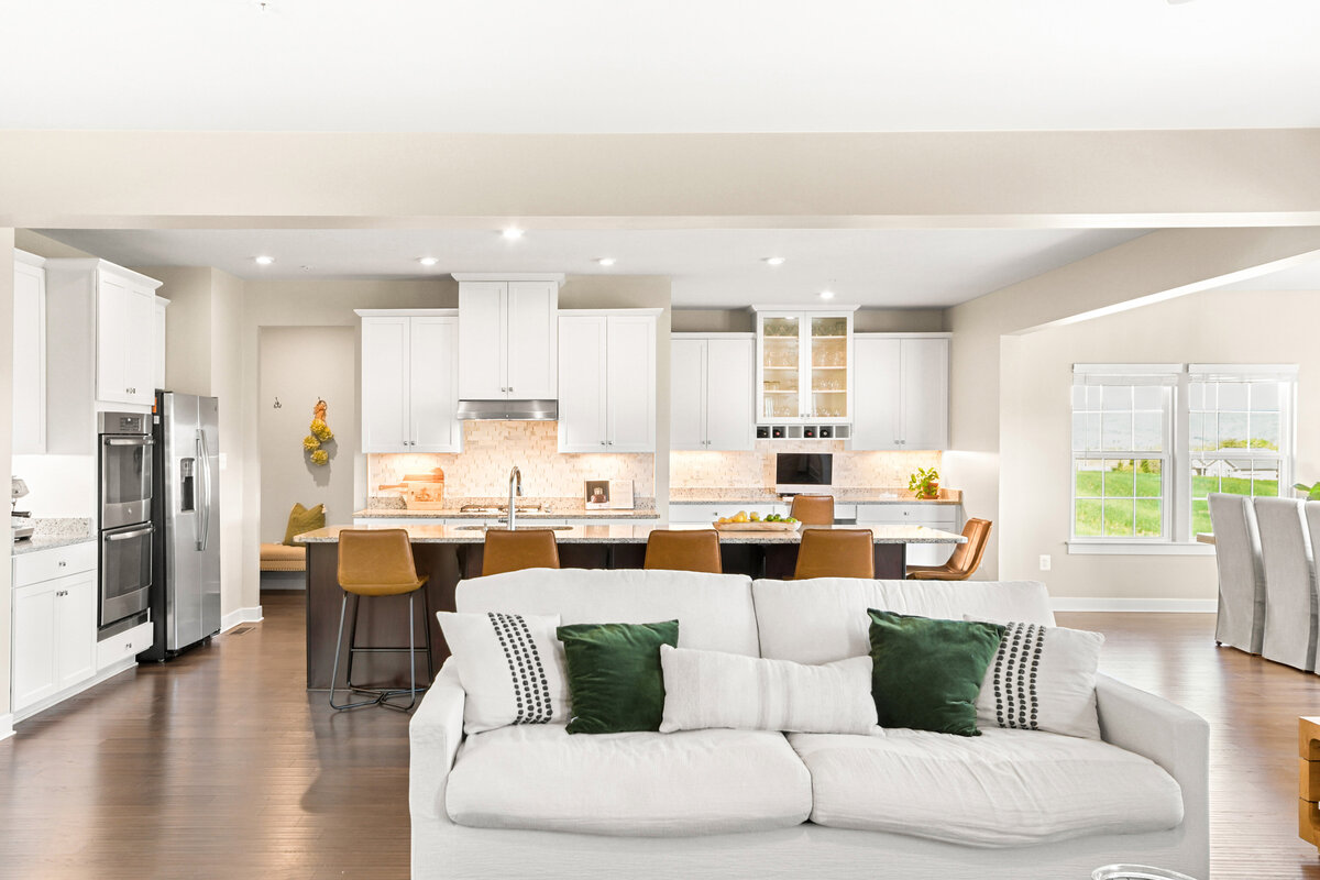 Living room and kitchen with green and leather accents