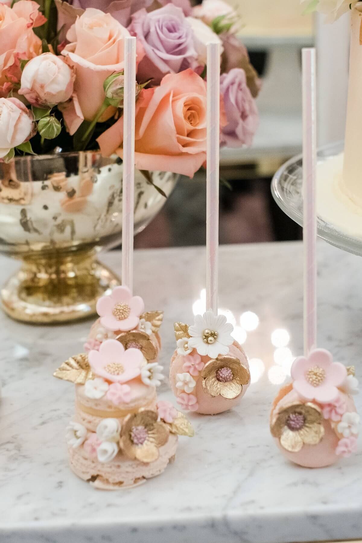 Elegant pink cake pops and macaroons decorated with sugar flowers