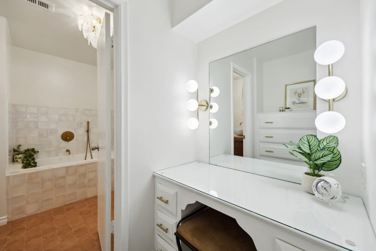 Elegant vanity with modern glam lighting and built-in makeup station in the primary bathroom at 3120 Chapel Downs Dr Dallas TX — Haven Realty Group listing.