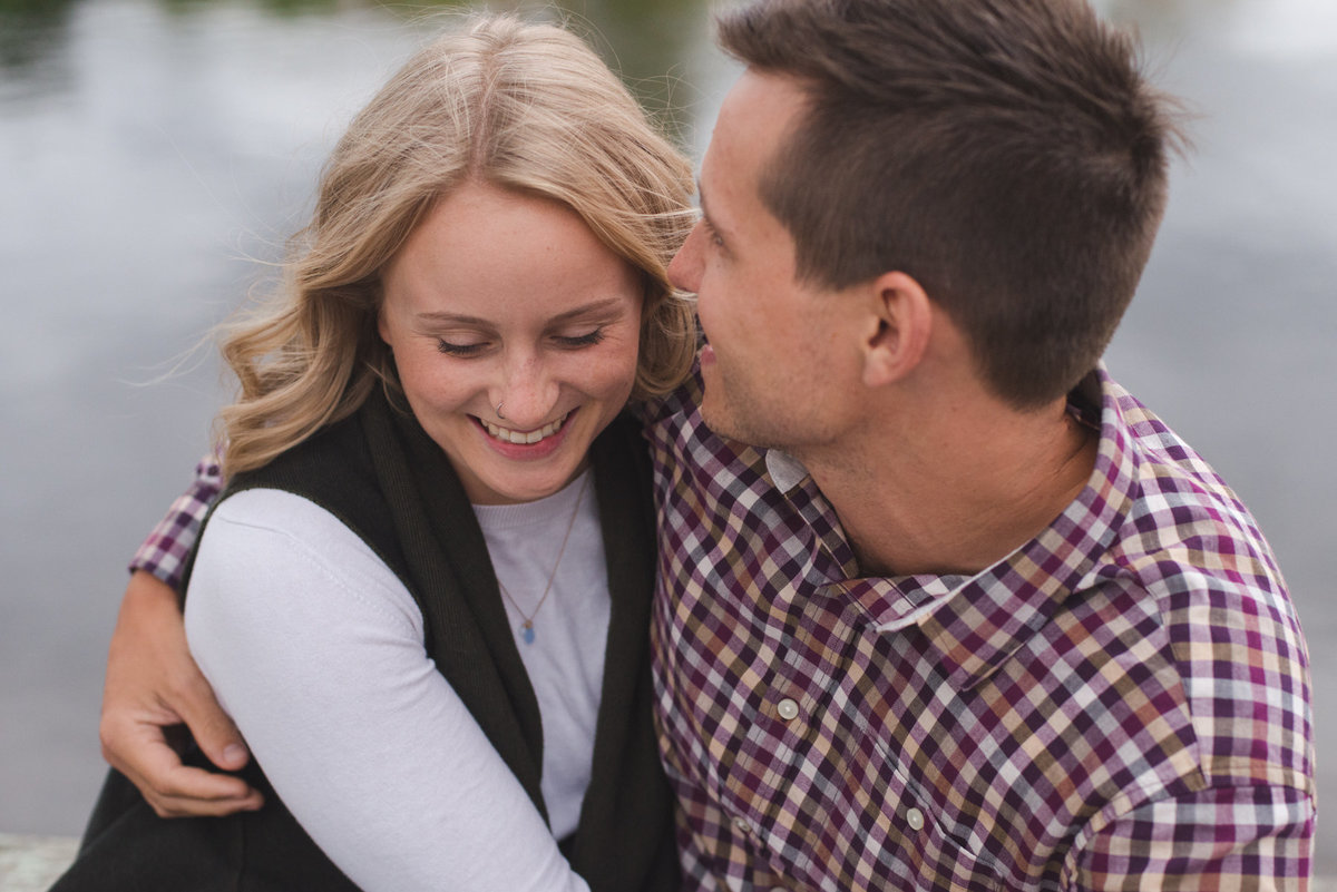 couple sitting together by the water laughing