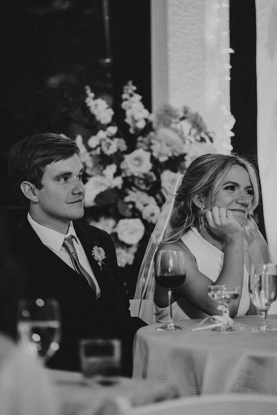 bride and groom smile fondly during wedding reception