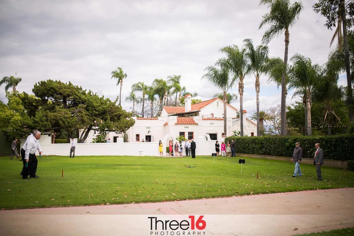 Wedding guests playing horseshoes on the lawn area at the Muckenthaler Mansion