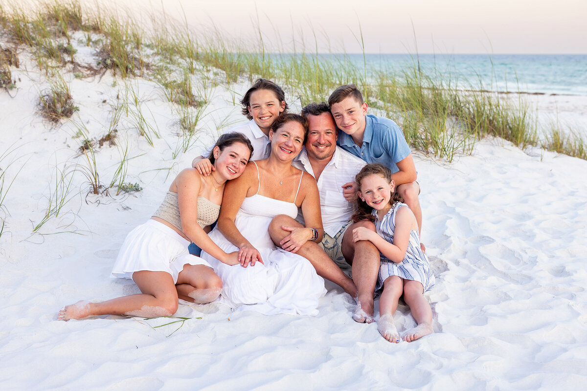 Family of 6 sitting for a beach portrait in destin Florida