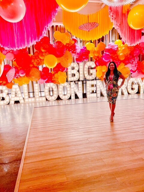 Red and gold balloon decor with a bold corporate event theme.