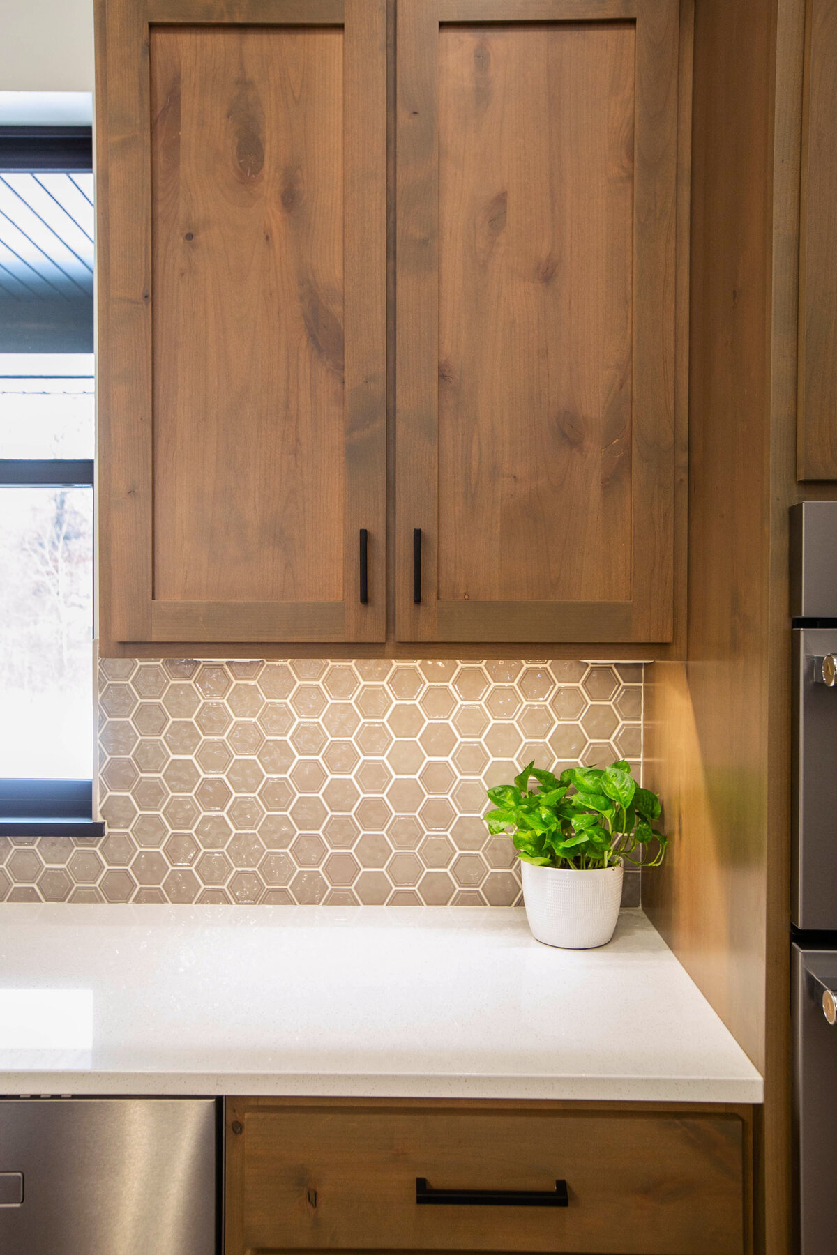 Open kitchen with dark cabinets, large island, and quartz countertops in an Elk River custom home