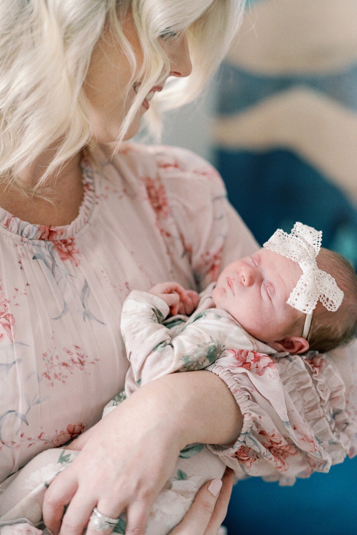 newborn-girl-with-head-bow-in-moms-arms