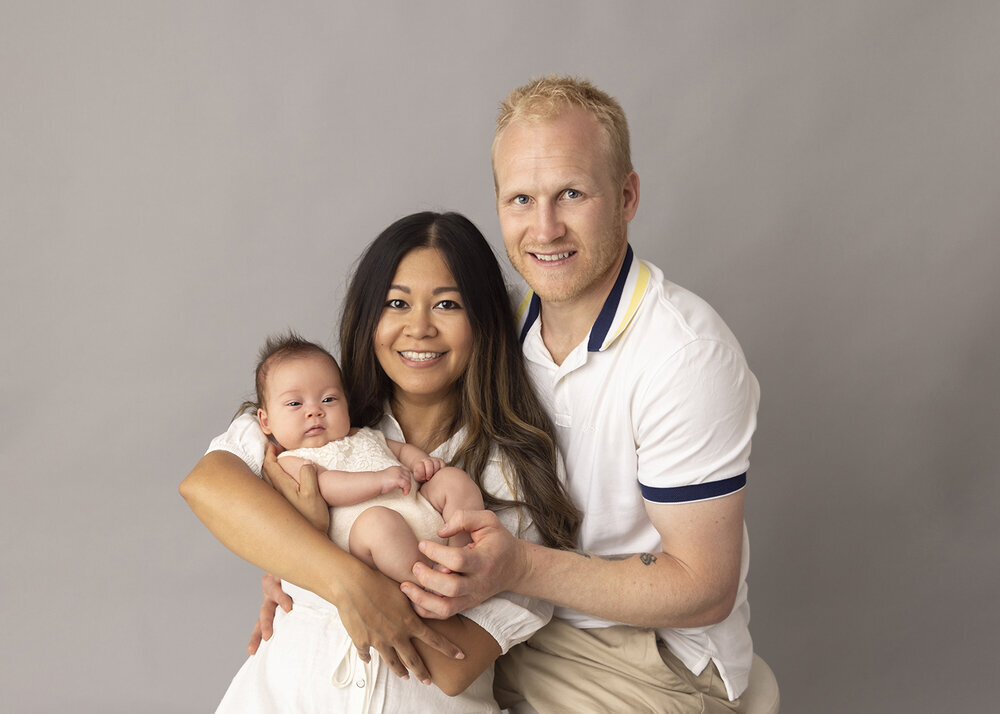 NEWBORN_BABY_GIRLWITHPARENTSSMILING