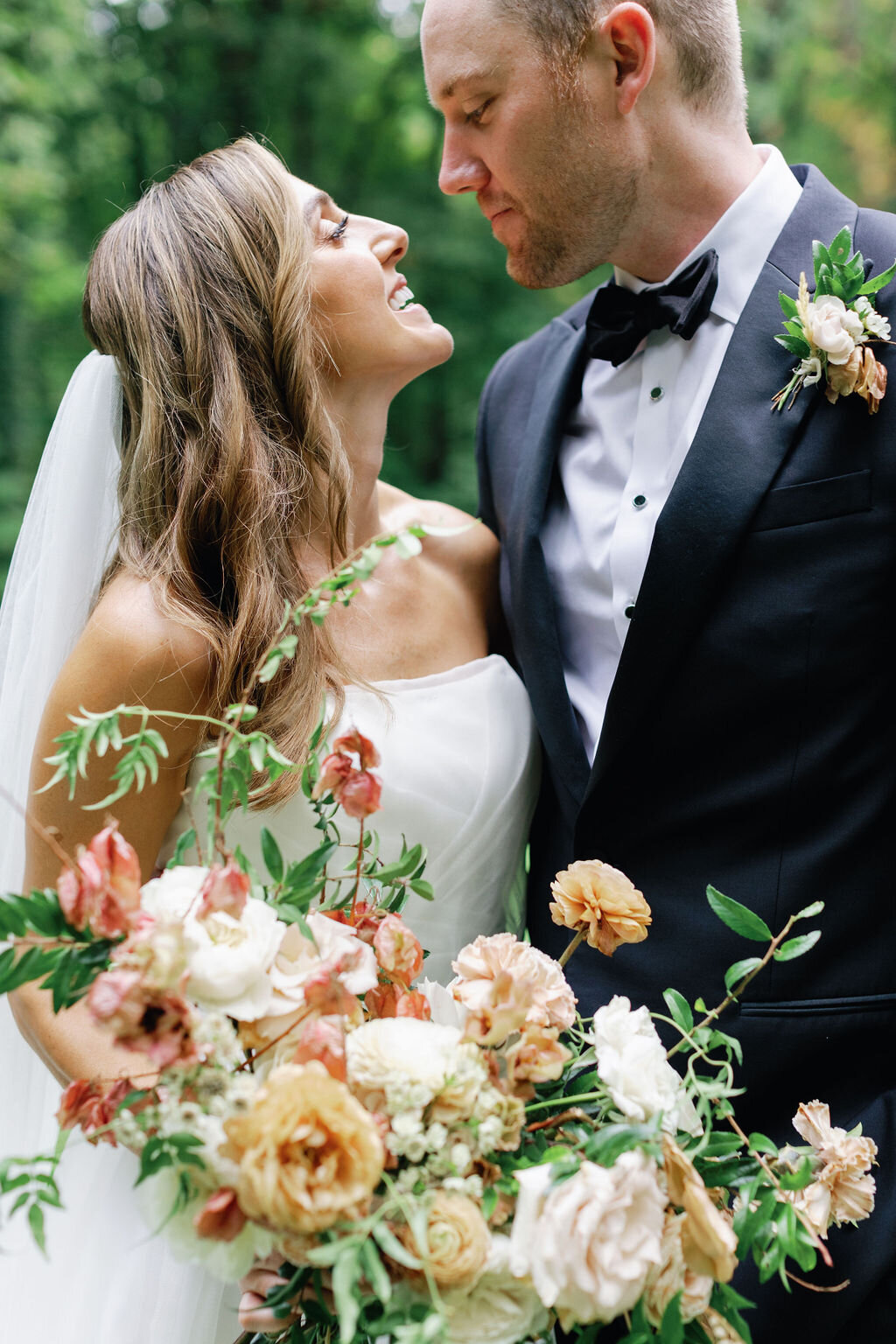 Lush bridal bouquet with dusty rose and copper flowers including garden roses, ranunculus, dried flowers, and natural greenery. Wedding floral design at RT Lodge by Rosemary and Finch in Nashville, TN.