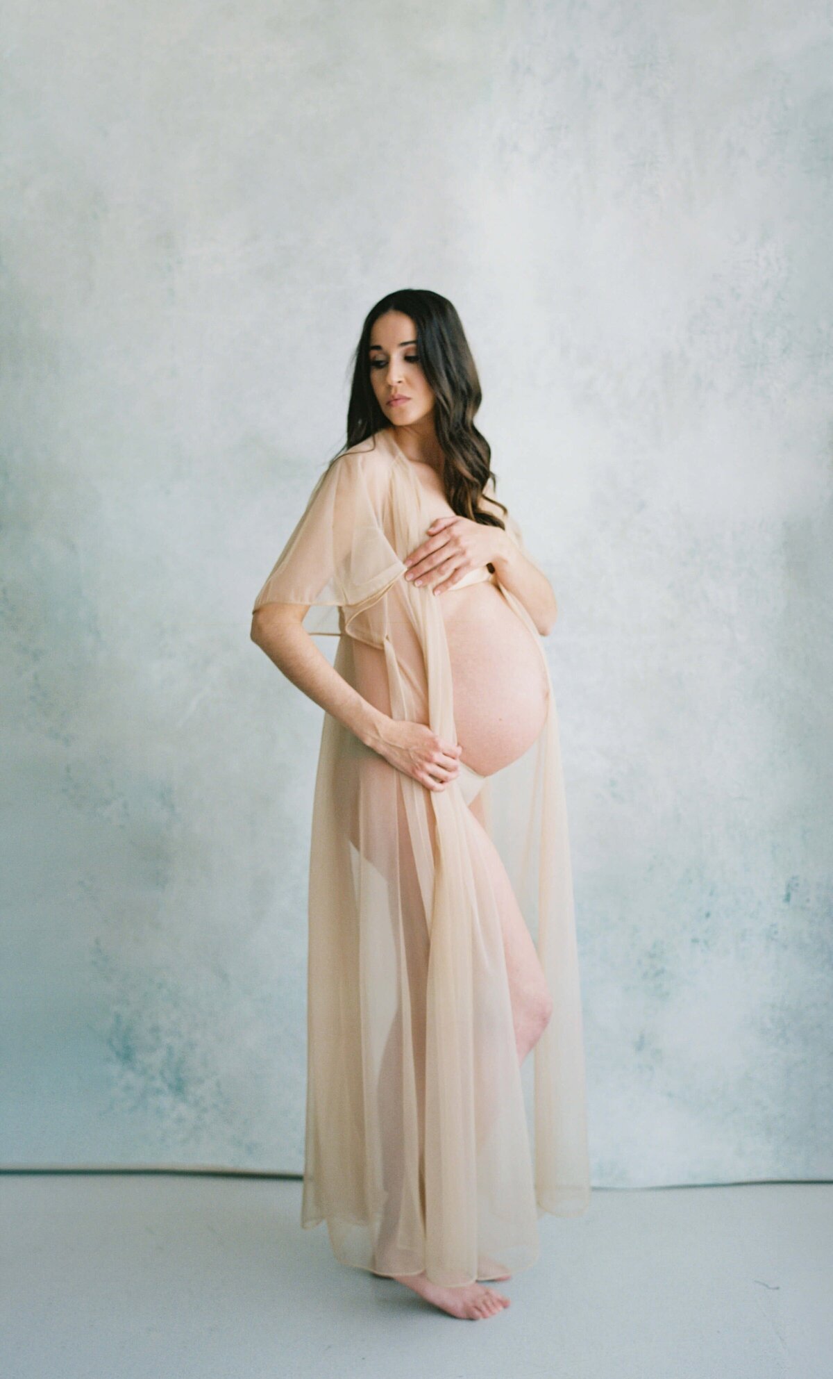 pregnant woman posing in nude dress for her studio maternity photos in san francisco