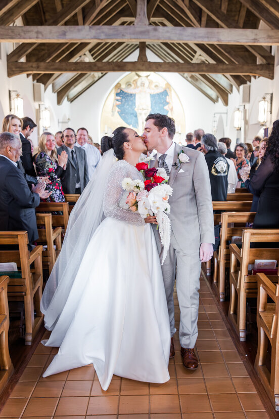 bride-and-groom-walking-down-aisle-at-mary-star-of-the-sea-catholic-church-wedding