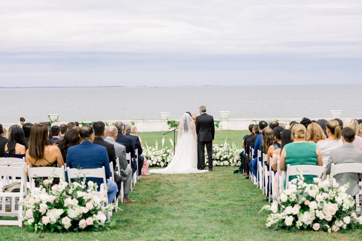 seatebride and groom at the top of the isle during wedding ceremony at rosecliff mansion in newport rhode island 