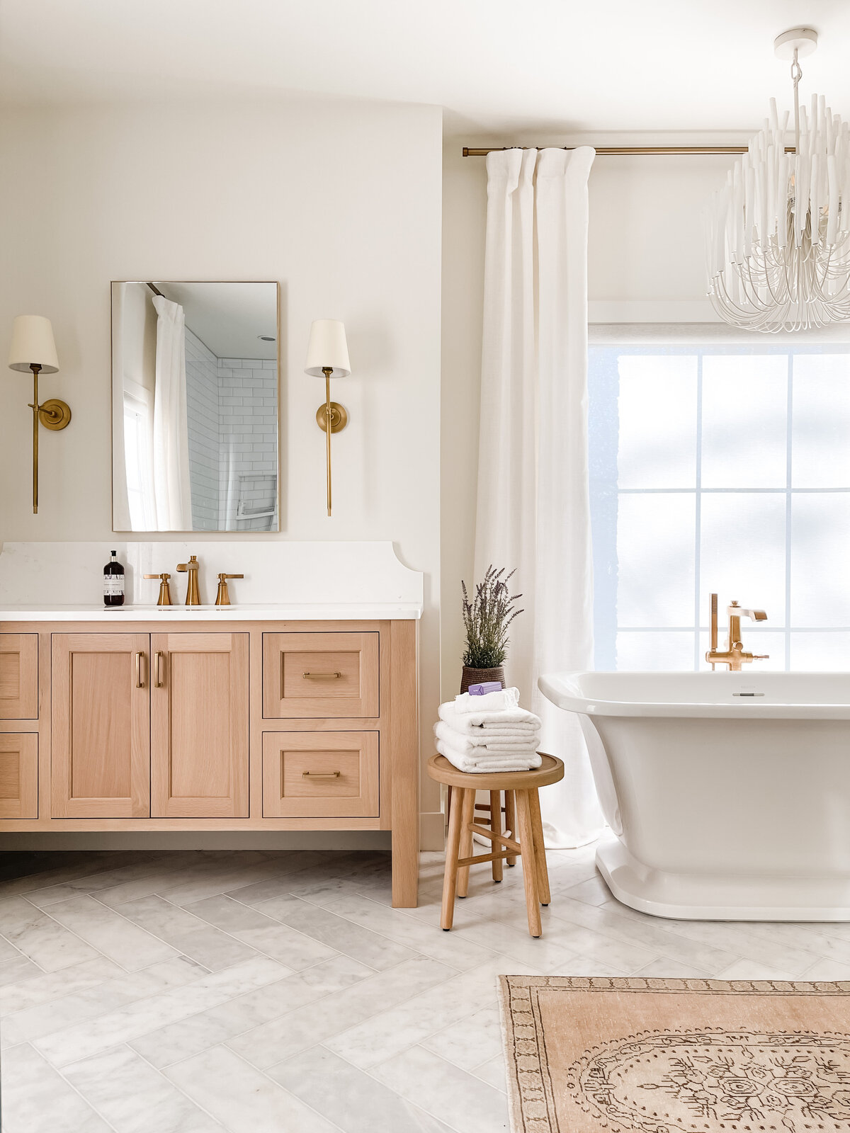 The his and hers vanities in the primary bathroom were made by a local Amish company and feature a warm custom stain with brass hardware