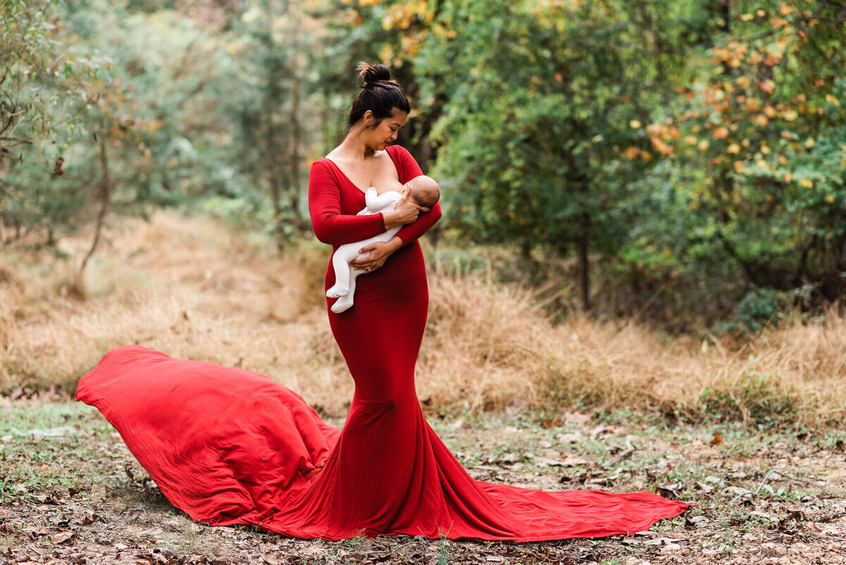 Mom wearing a gorgeous red flowing gown, breastfeeding her son, by a Northern VA newborn photographer