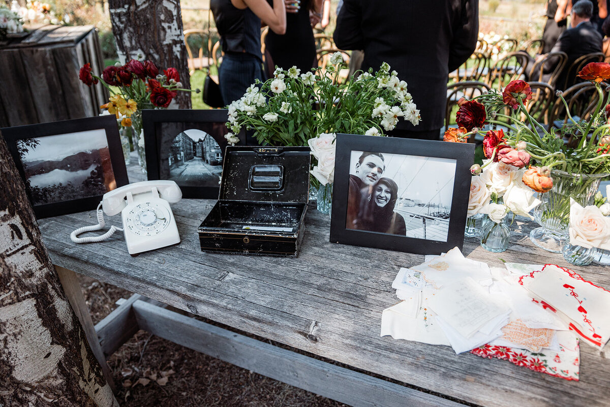 A wooden table with pictures and flowers.