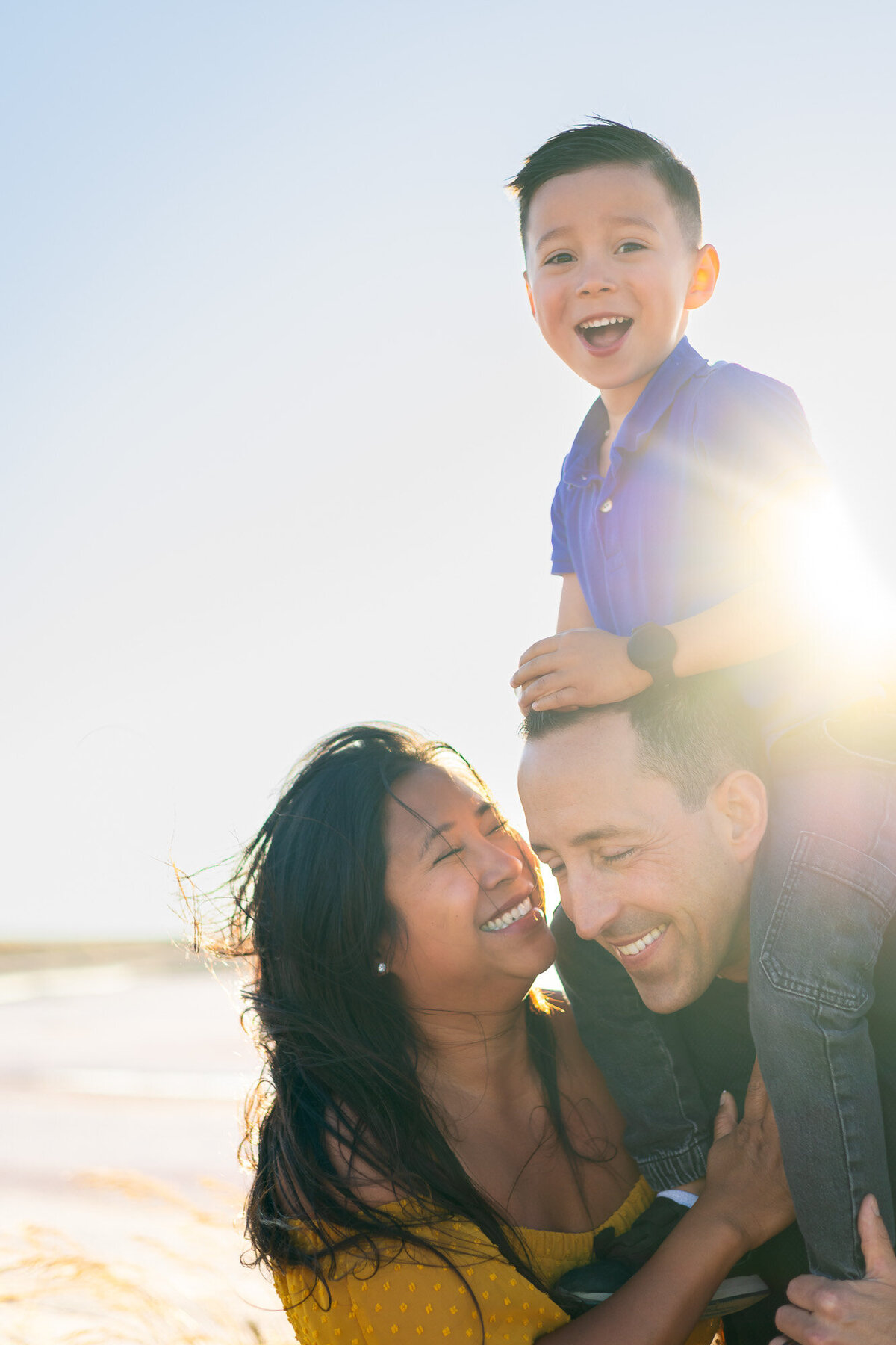 Smiling boy sits on dad’s shoulders as mom and dad laugh together – Bay Area Family Portfolio - Ellobelle Photography