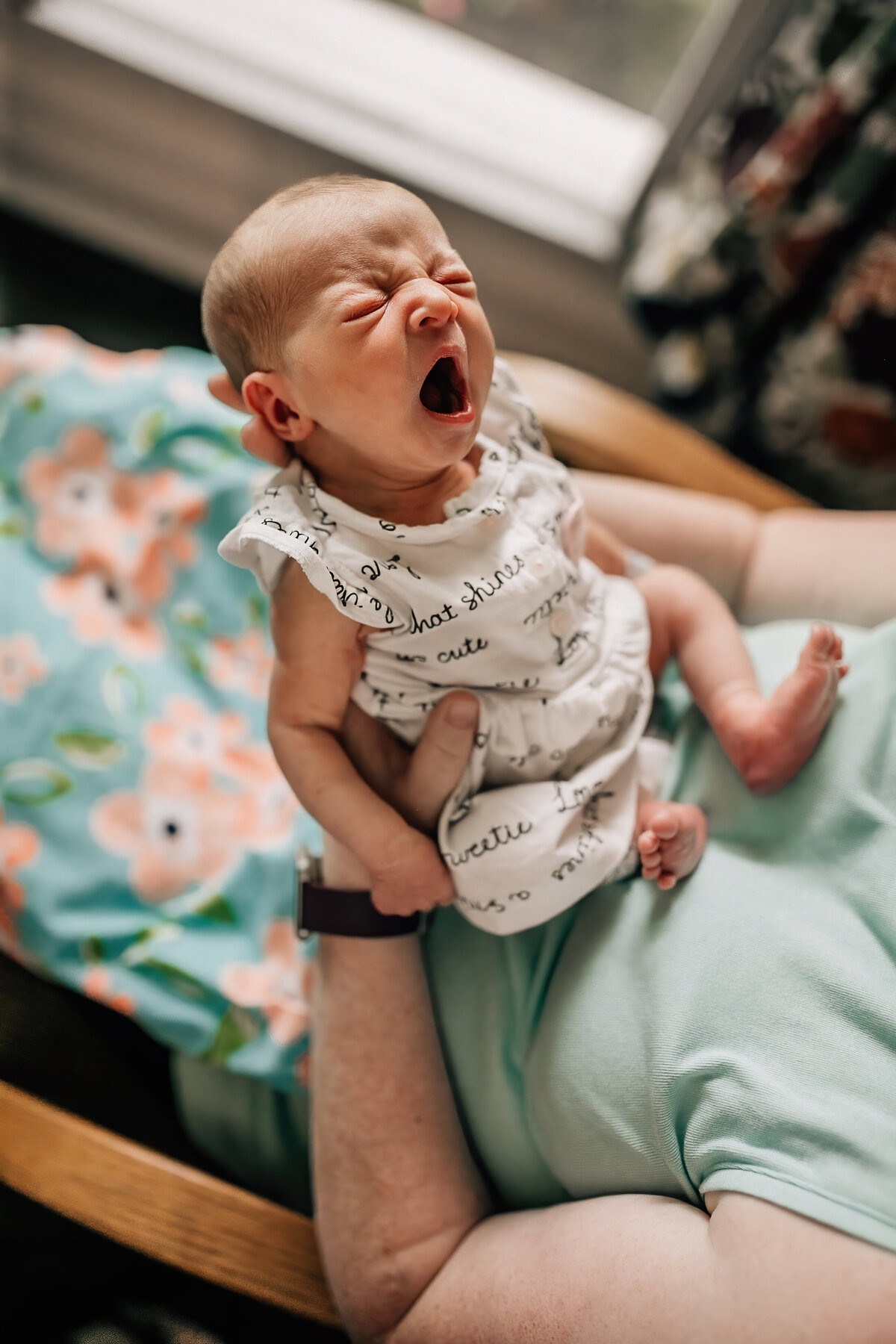 Newborn photography of a baby being held by dad.